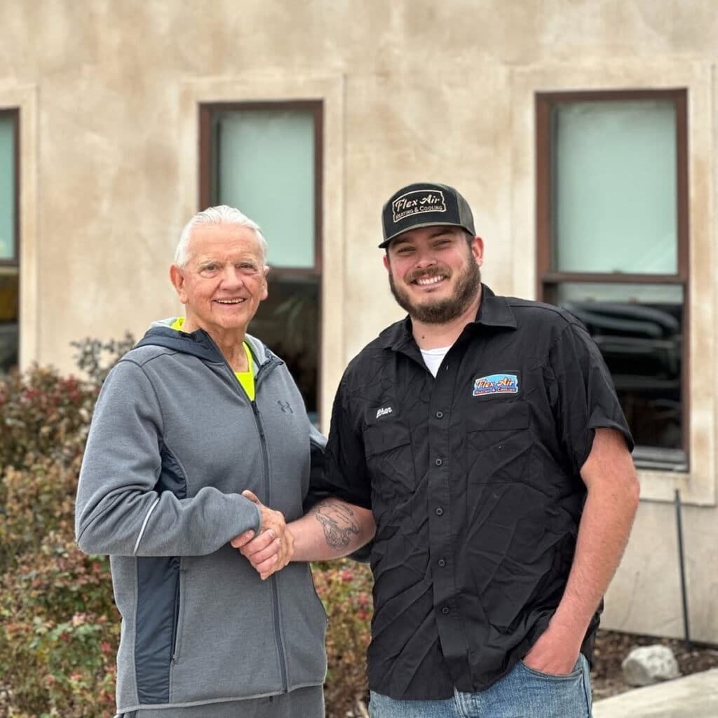 Flex Air Heating and Cooling technician shaking hands with a happy customer outside a home